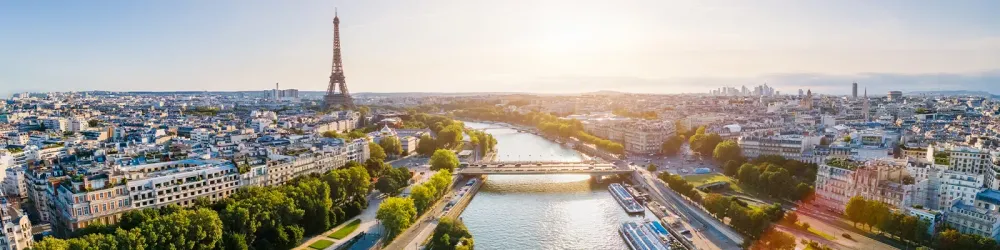 Paris aerial panorama with river Seine and Eiffel tower, France. Romantic summer holidays vacation destination. Panoramic view above historical Parisian buildings and landmarks with blue sky and sun